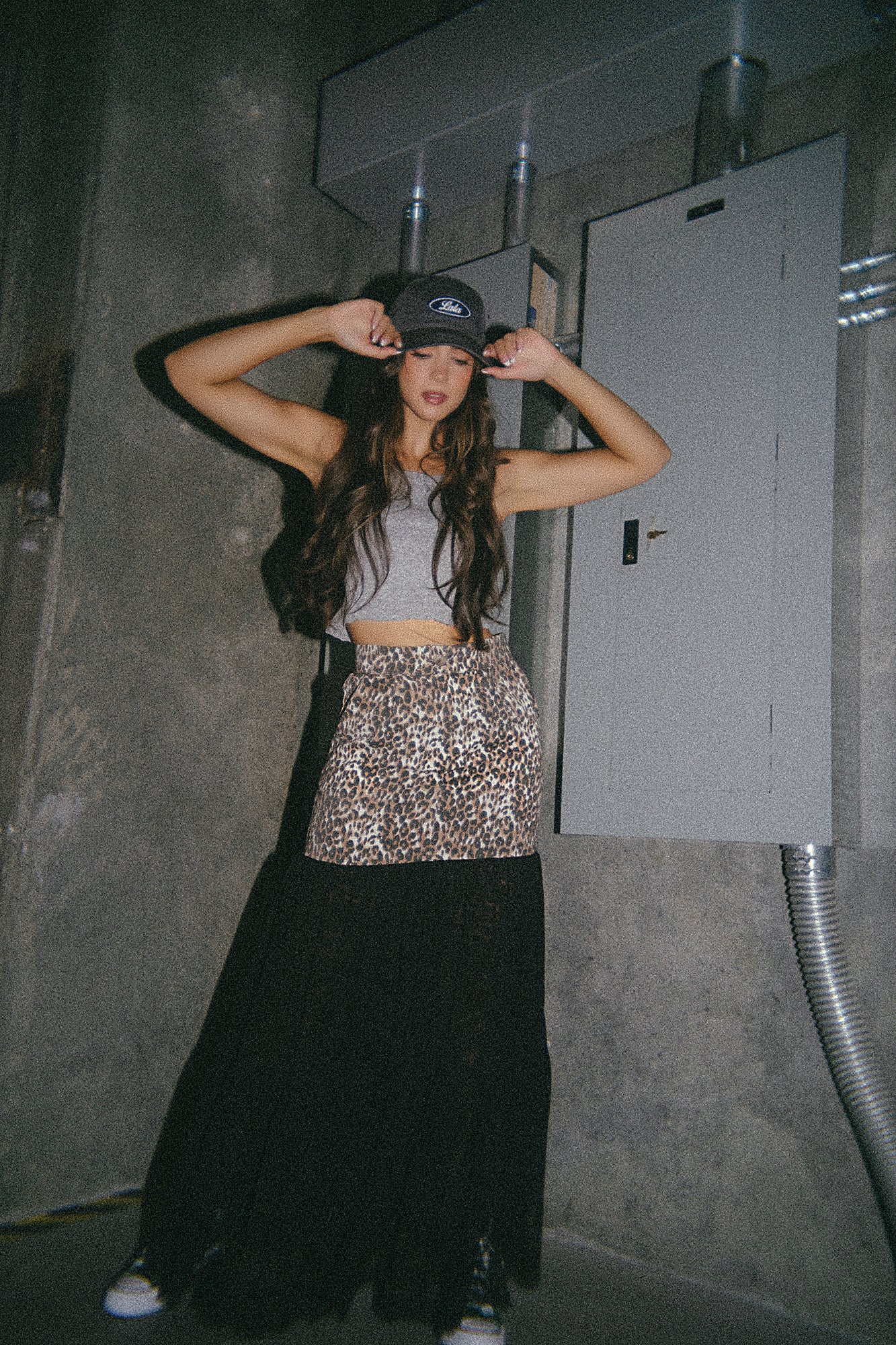 Person wearing a sparkly top and long black skirt in a dimly lit room.