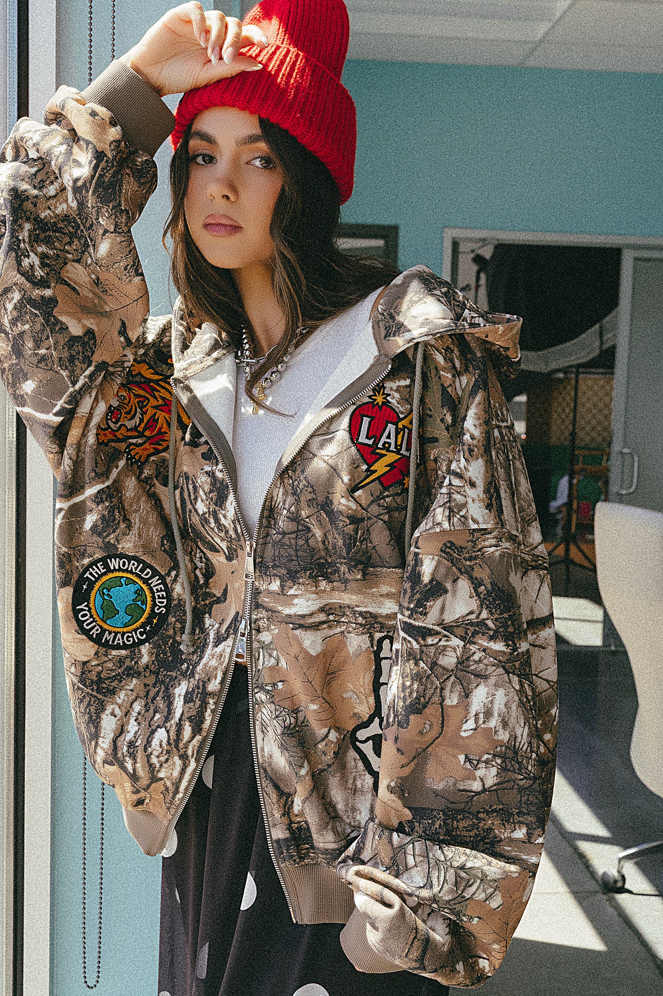 Person wearing a camouflage jacket with patches indoors