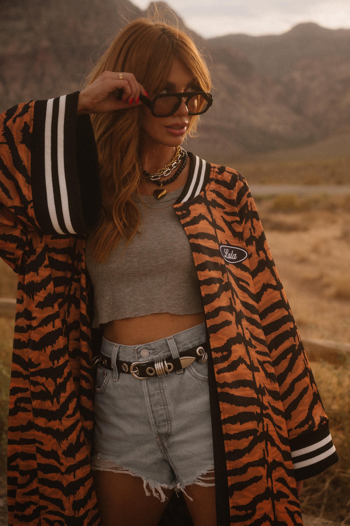 Person wearing a tiger-striped coat in a desert setting