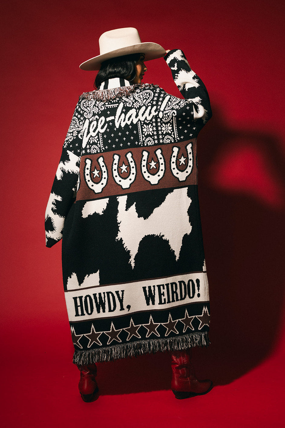 Person wearing a patterned cardigan with text on a red background