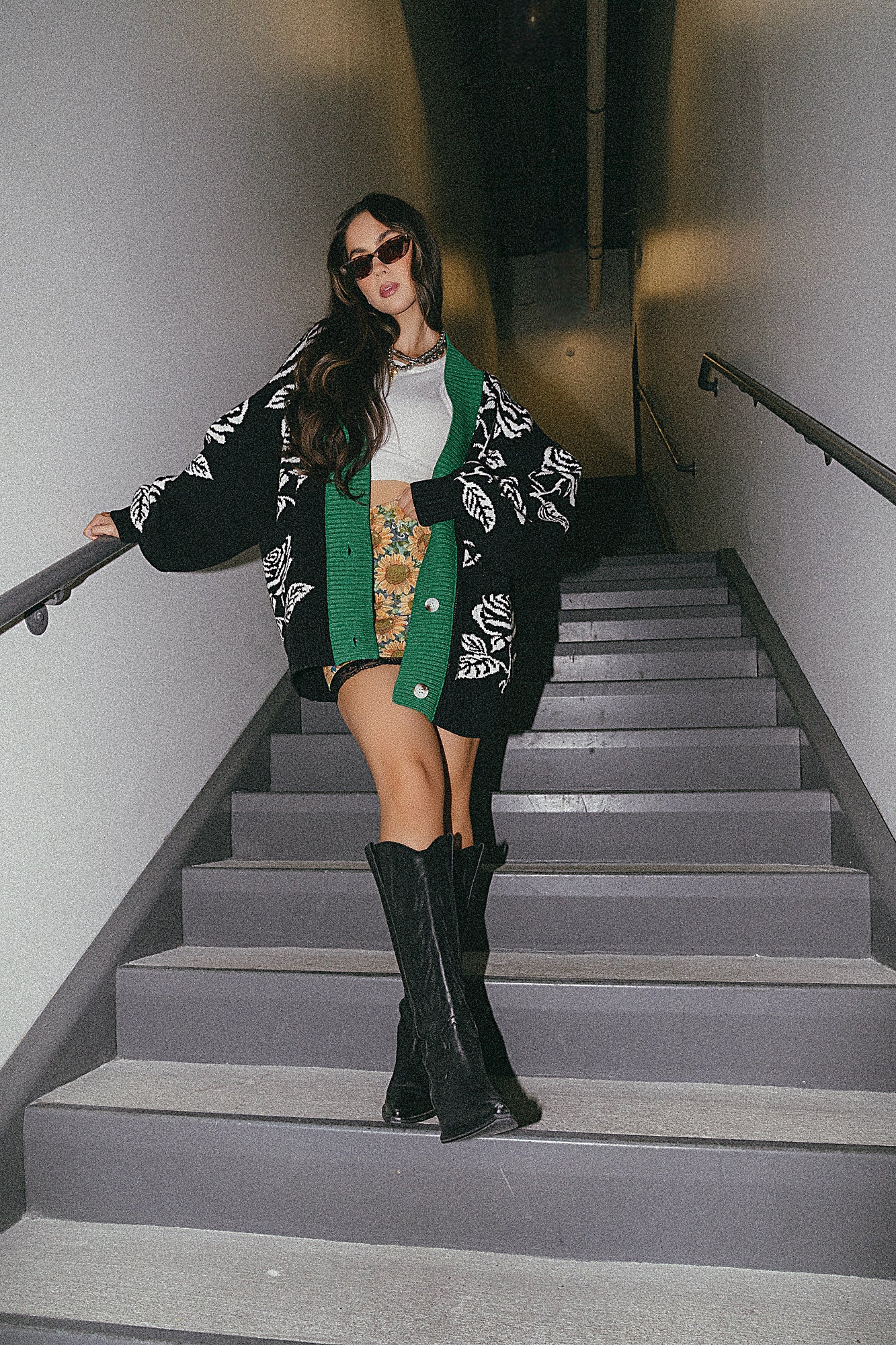 Woman in a stylish outfit standing on a staircase