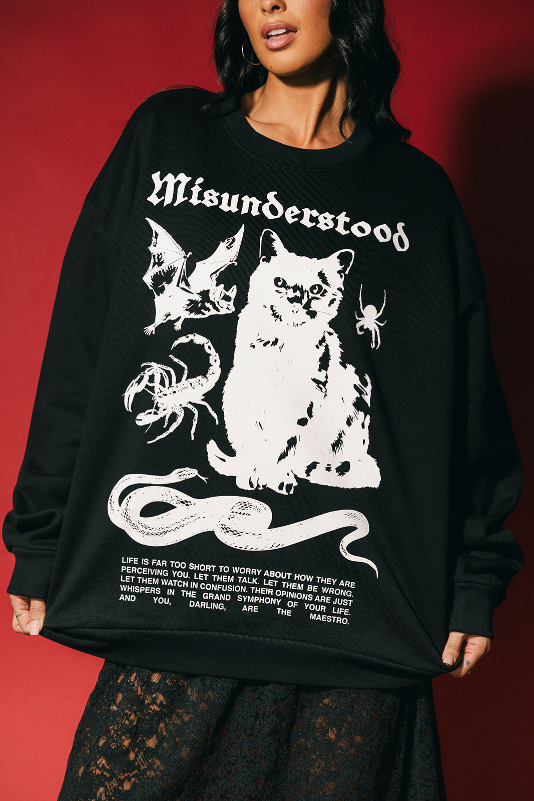 Person wearing a black sweatshirt with white graphic design and text on a red background