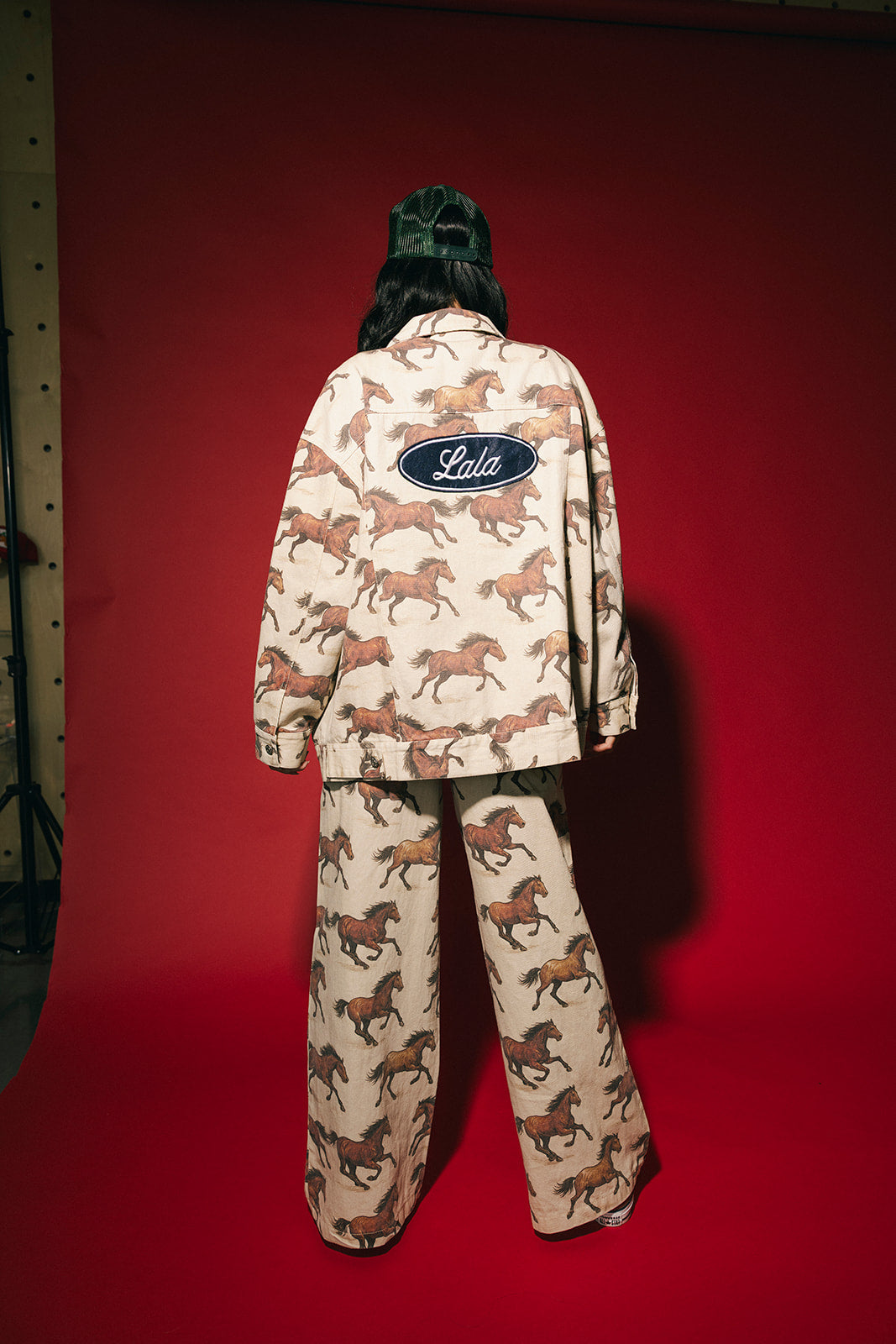 White denim jacket with a horse pattern and Lala logo on a red background