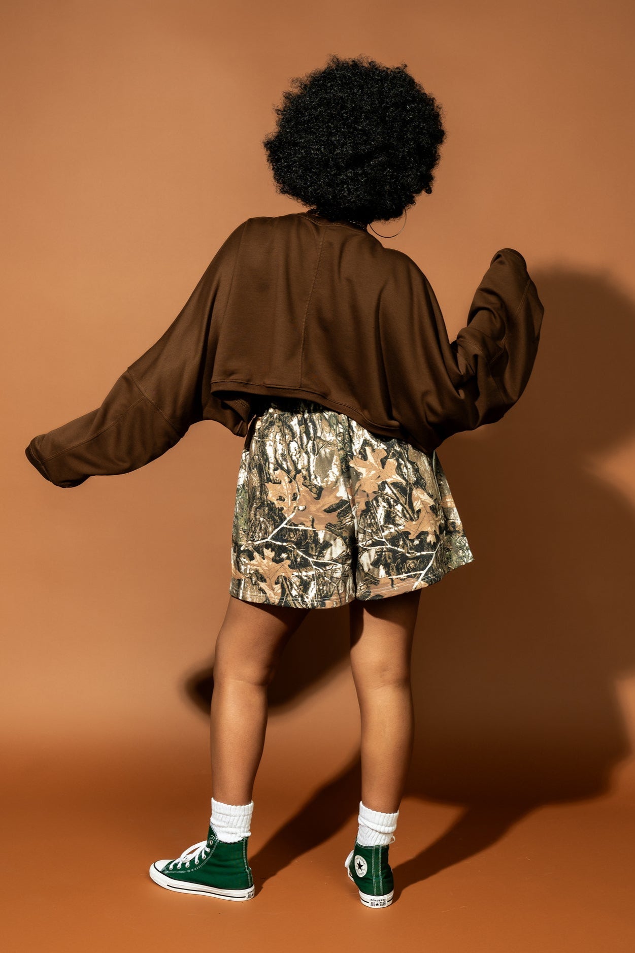 photo of girl wearing real tree camo sweat boxer shorts with an elastic waistband, side pockets, three faux button fly, and white satin label that says "lala"