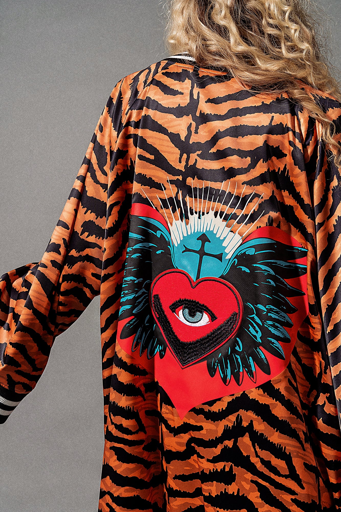 Tiger-striped robe with a red heart and blue eye design on a gray background