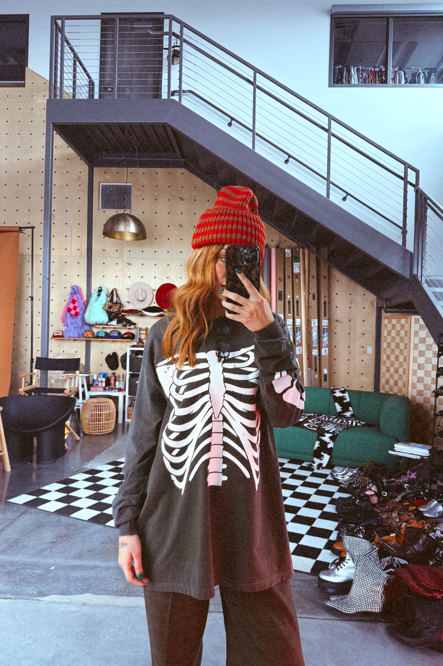 Person wearing a skeleton-patterned sweater in a modern interior setting