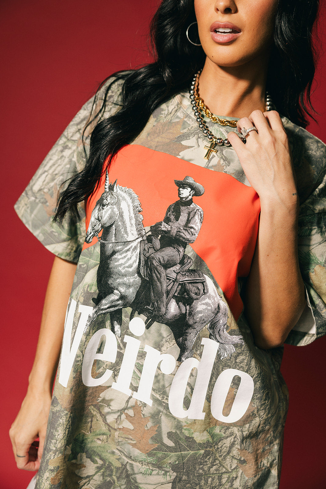 Person wearing a graphic t-shirt with a cowboy design and the word 'Weirdo' on a red background