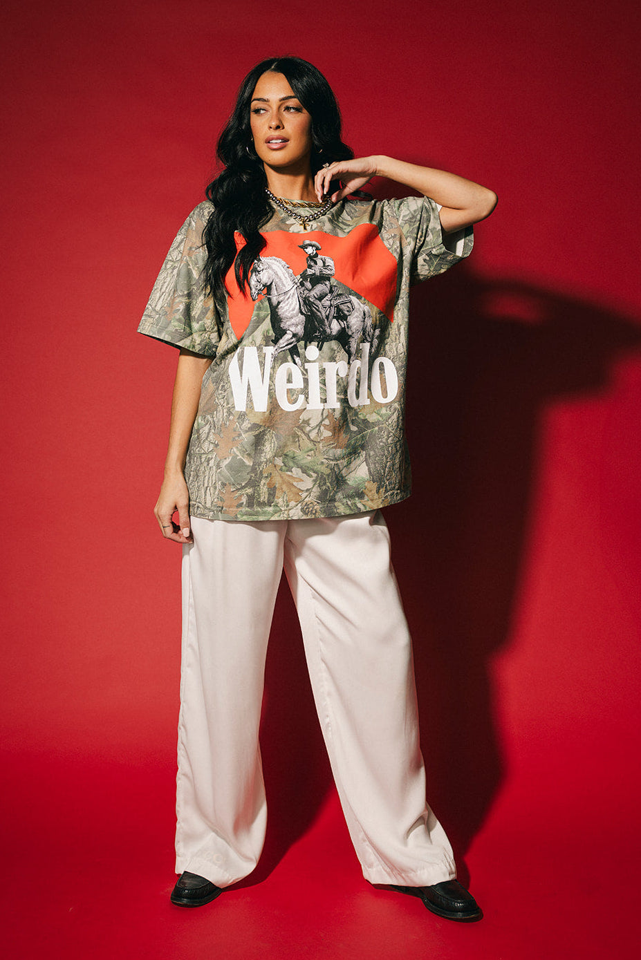 Person wearing a graphic t-shirt with text and design on a red background