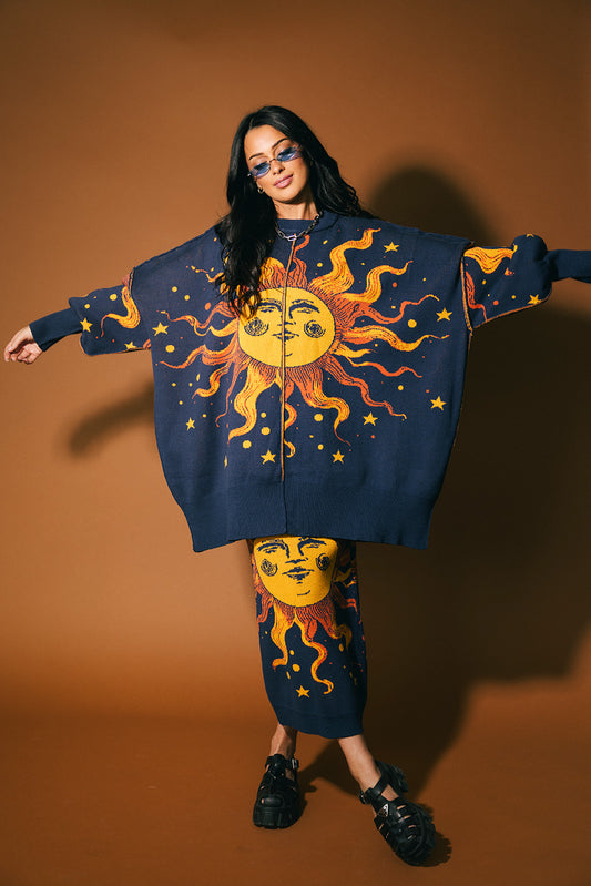 Woman wearing a blue sweater with sun and moon design against a brown background