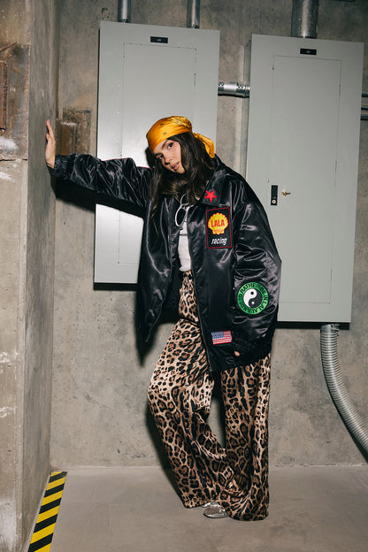 Person wearing a black jacket with patches in an industrial setting