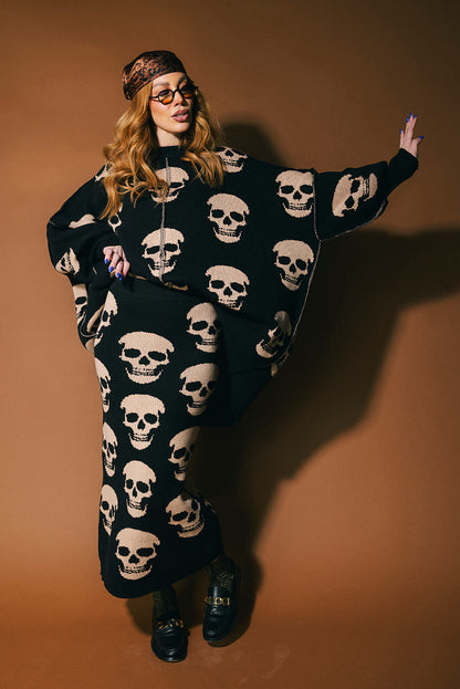 Person wearing a black knit skirt with skull pattern against a brown background