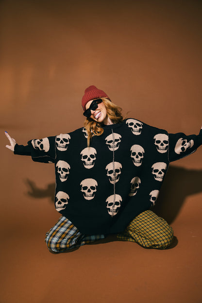 Person wearing a black skull-patterned sweater with a brown background
