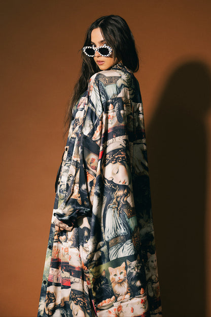 Woman wearing a long, renaissance cat satin dress against a brown background