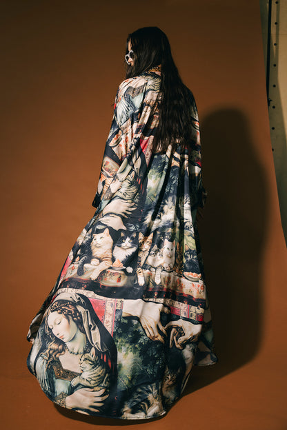 Woman wearing a renaissance cat pattern satin duster against a brown background.