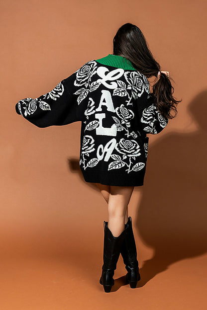Person wearing a black jacket with white designs on a brown background