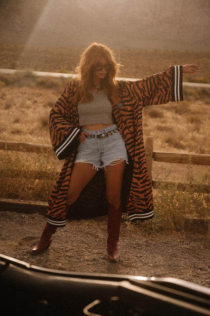Person wearing a tiger-striped coat in a desert setting
