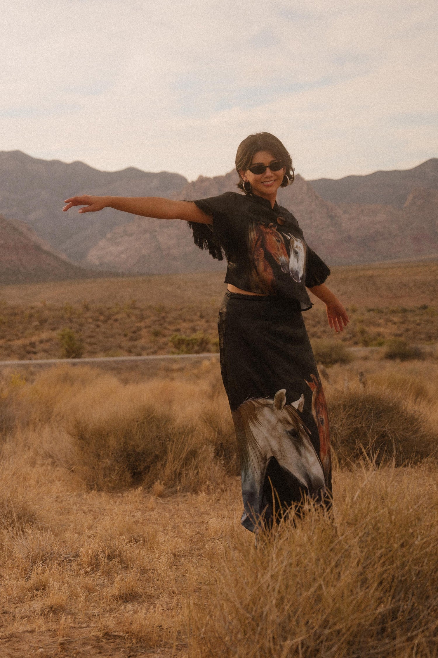 Person standing in a desert landscape with mountains in the background