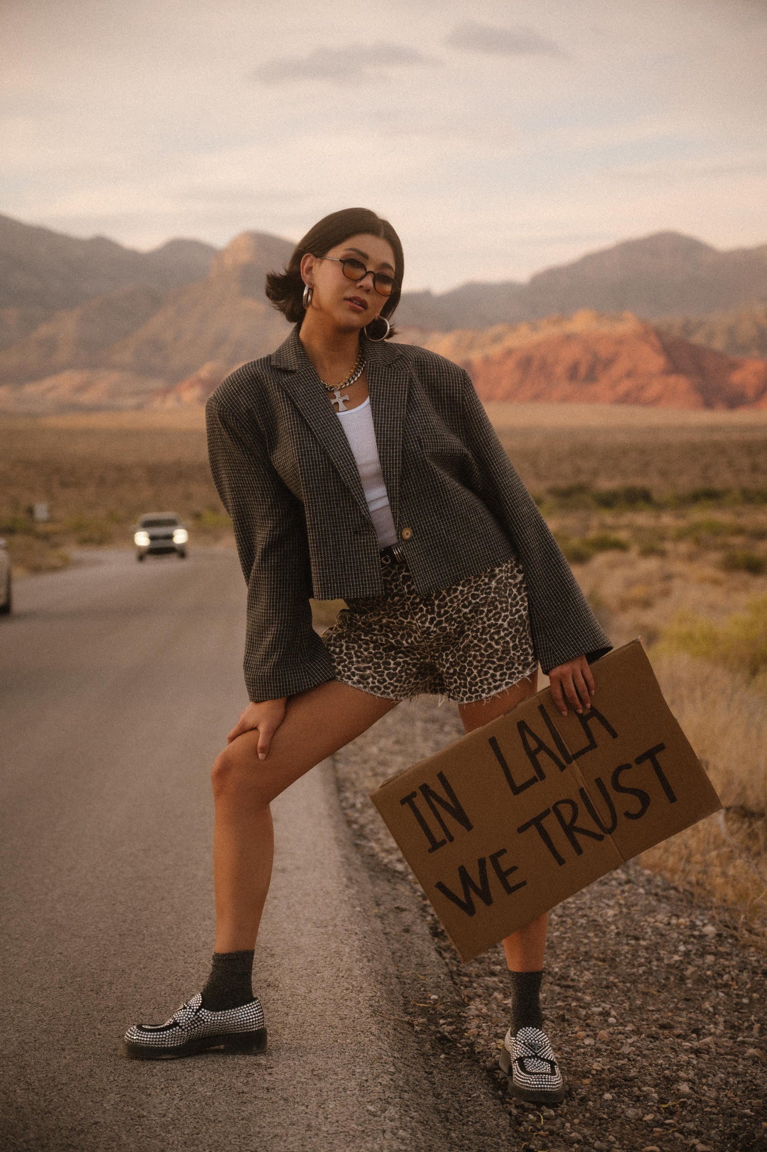 Person holding a sign in the desert with mountains in the background