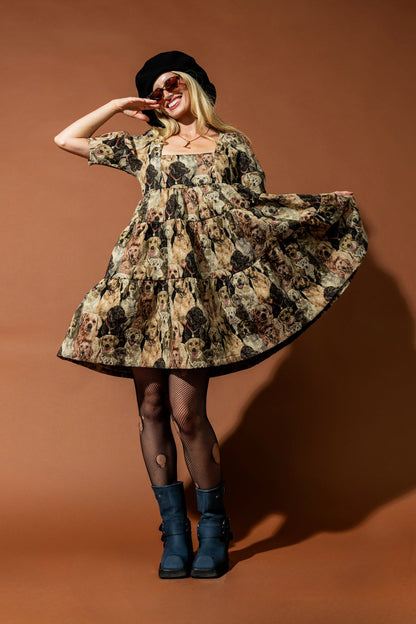 Woman in a floral dress and blue boots posing against a brown background