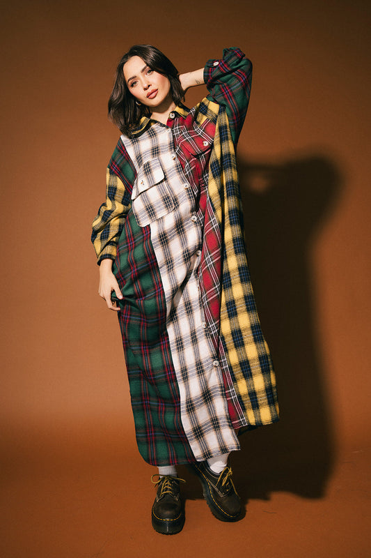 Person wearing a patchwork plaid dress  against a brown background