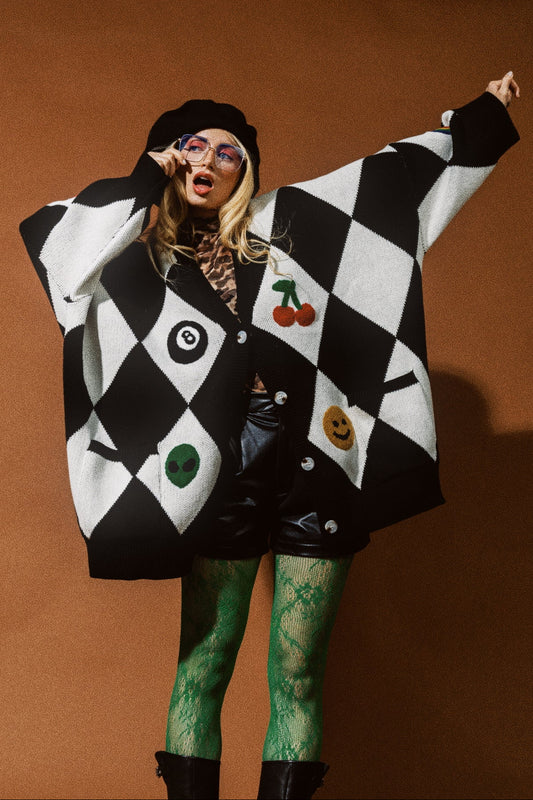 Person wearing a black and white checkered outfit with colorful designs on a brown background