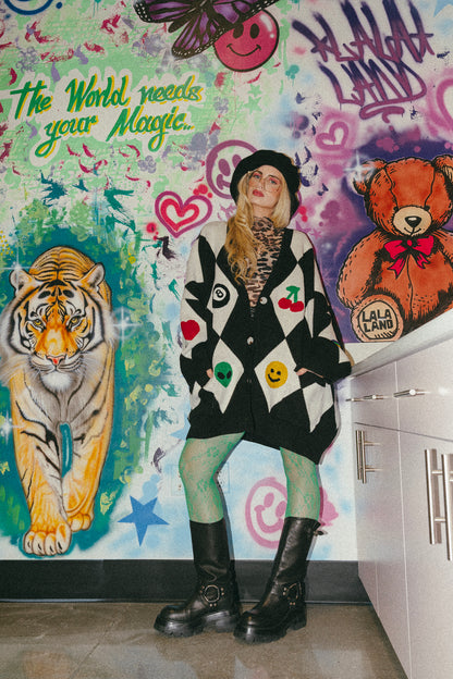 Person in a colorful room with a tiger, teddy bear, and text on the wall.