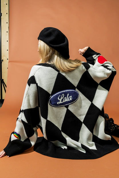 Person wearing a black and white checkered sweater with 'Lala' logo on a brown background