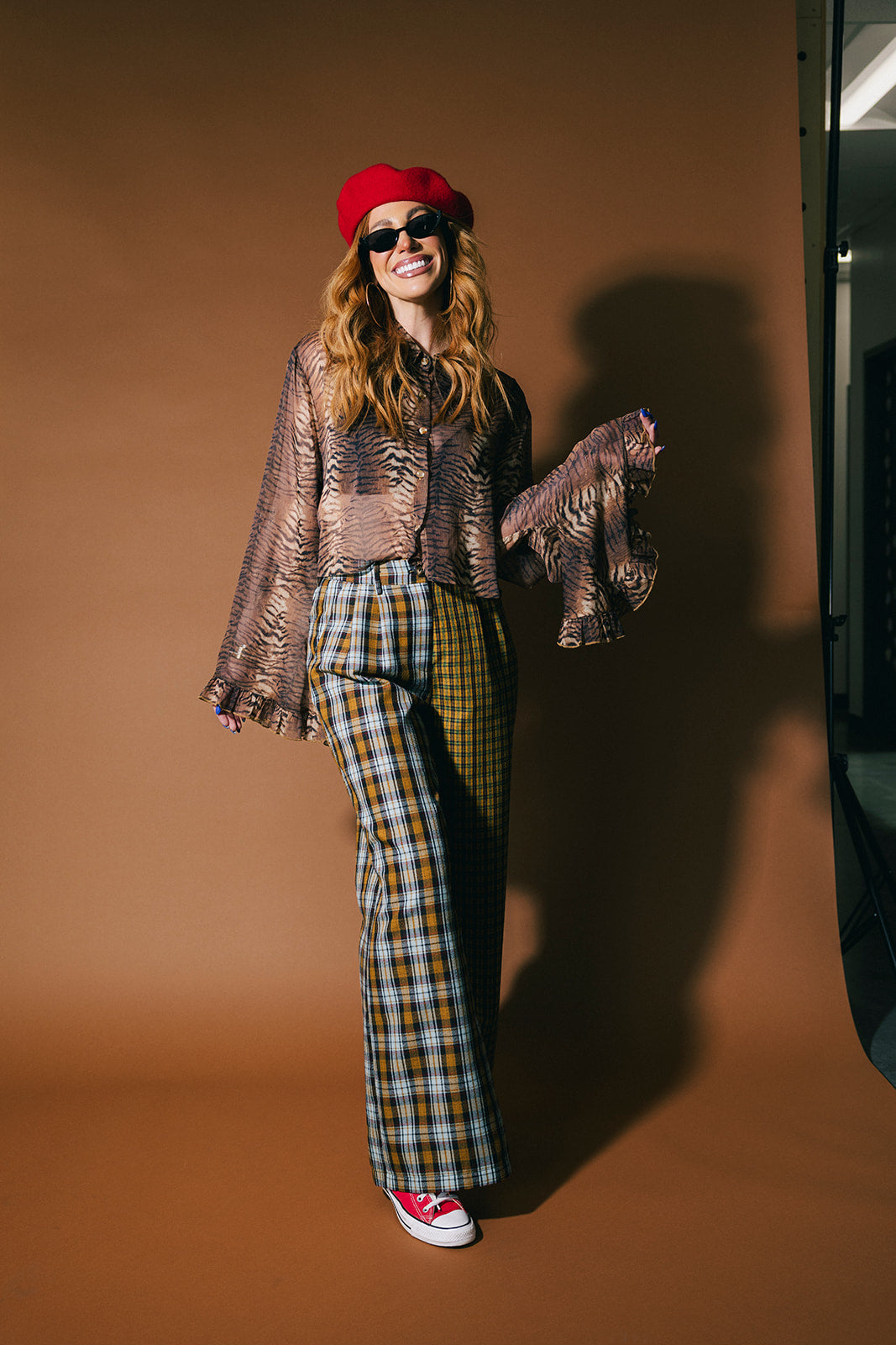 Person wearing plaid half and half trousers on a brown background