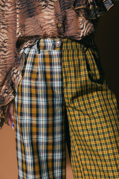 Person wearing plaid half and half trousers on a brown background