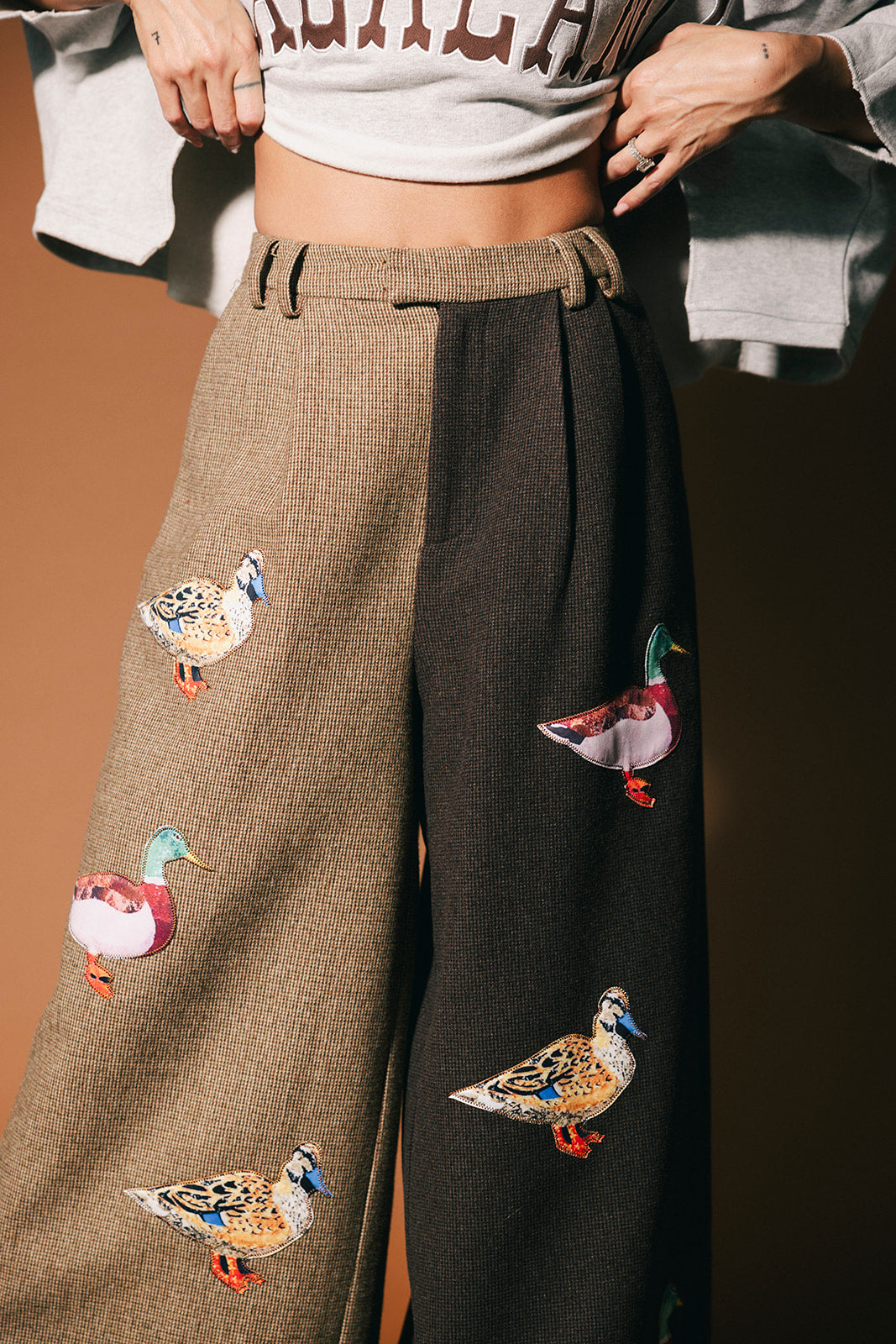 Half and half pants with duck patches on a brown background