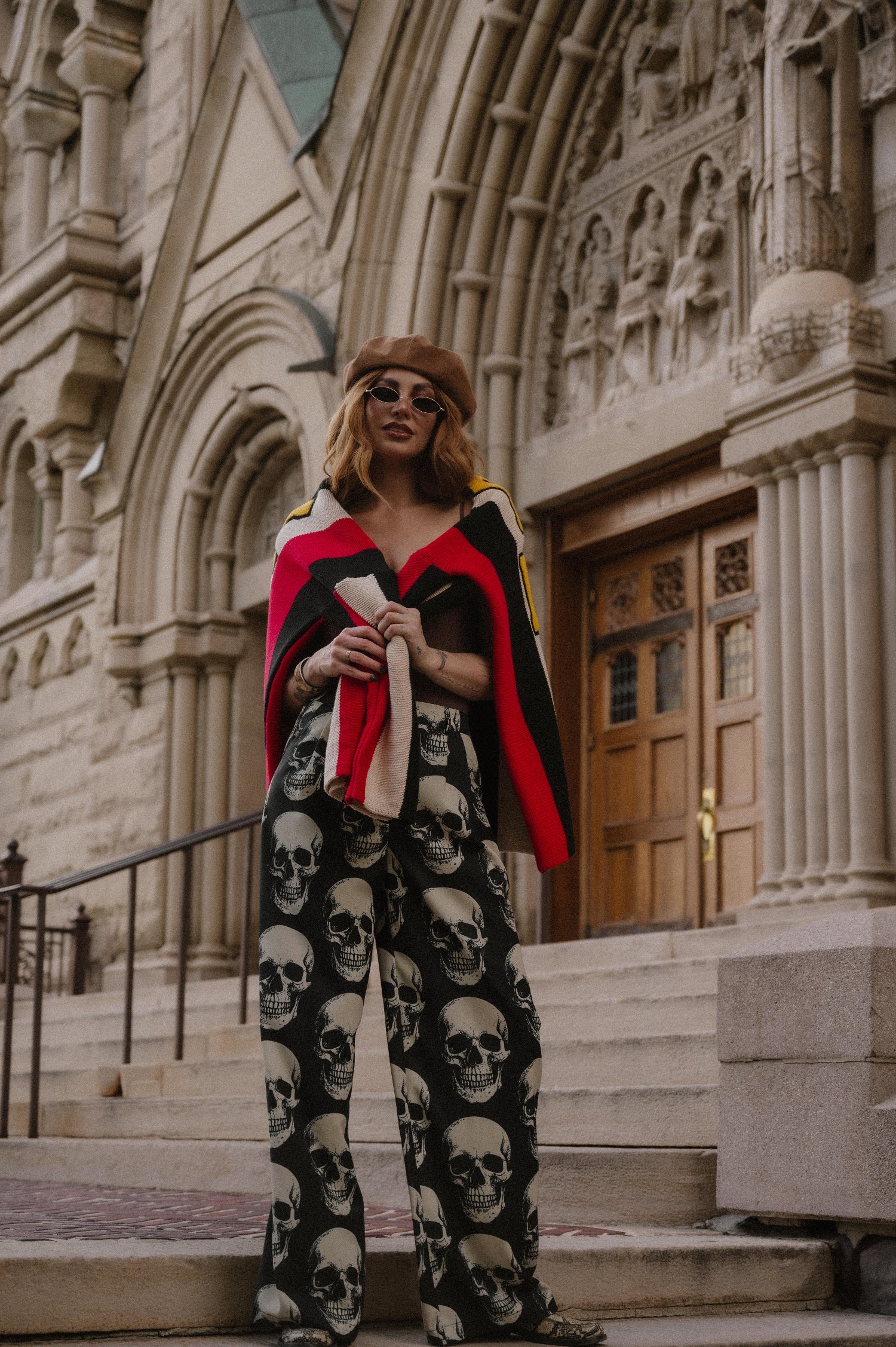 Person wearing skull-patterned trousers in front of a cathedral.