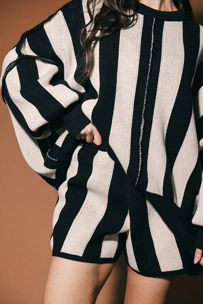 Black and white striped sweater worn by a person on a brown background