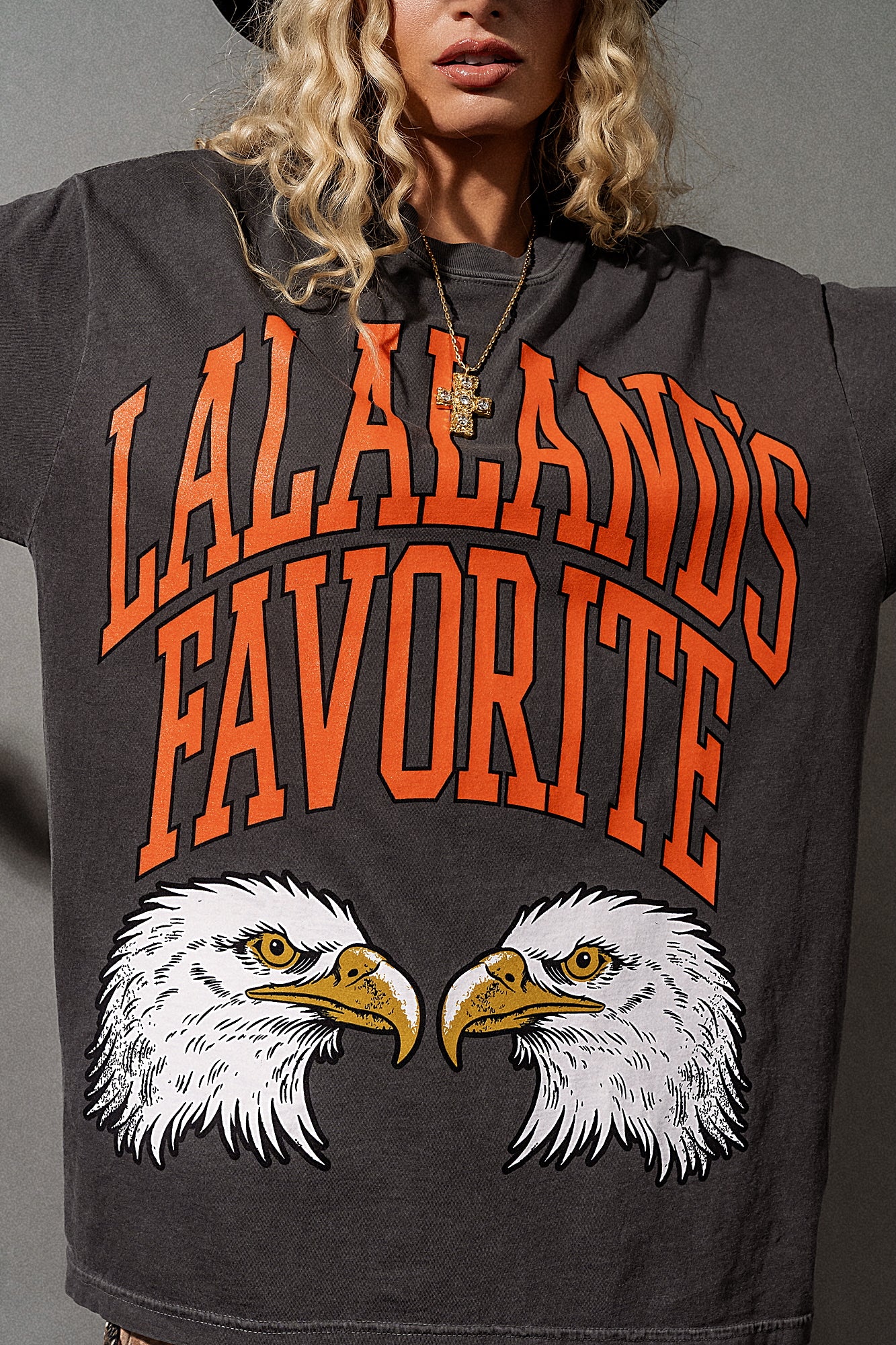 Person wearing a hoodie with 'Lalaland's Favorite' text and eagle design.