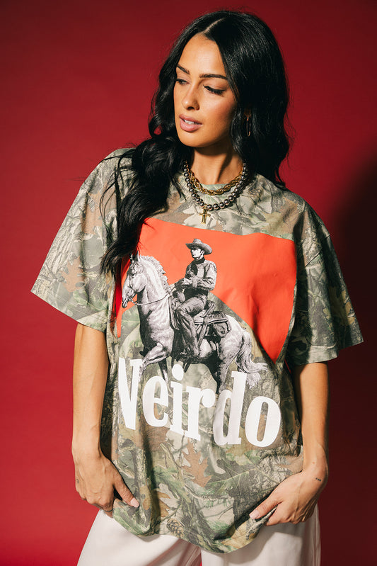 Woman wearing a camouflage shirt with a graphic and the word 'Weirdo' on a red background