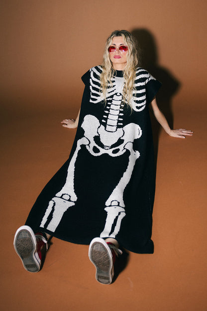 Person wearing a black skeleton costume against a brown background