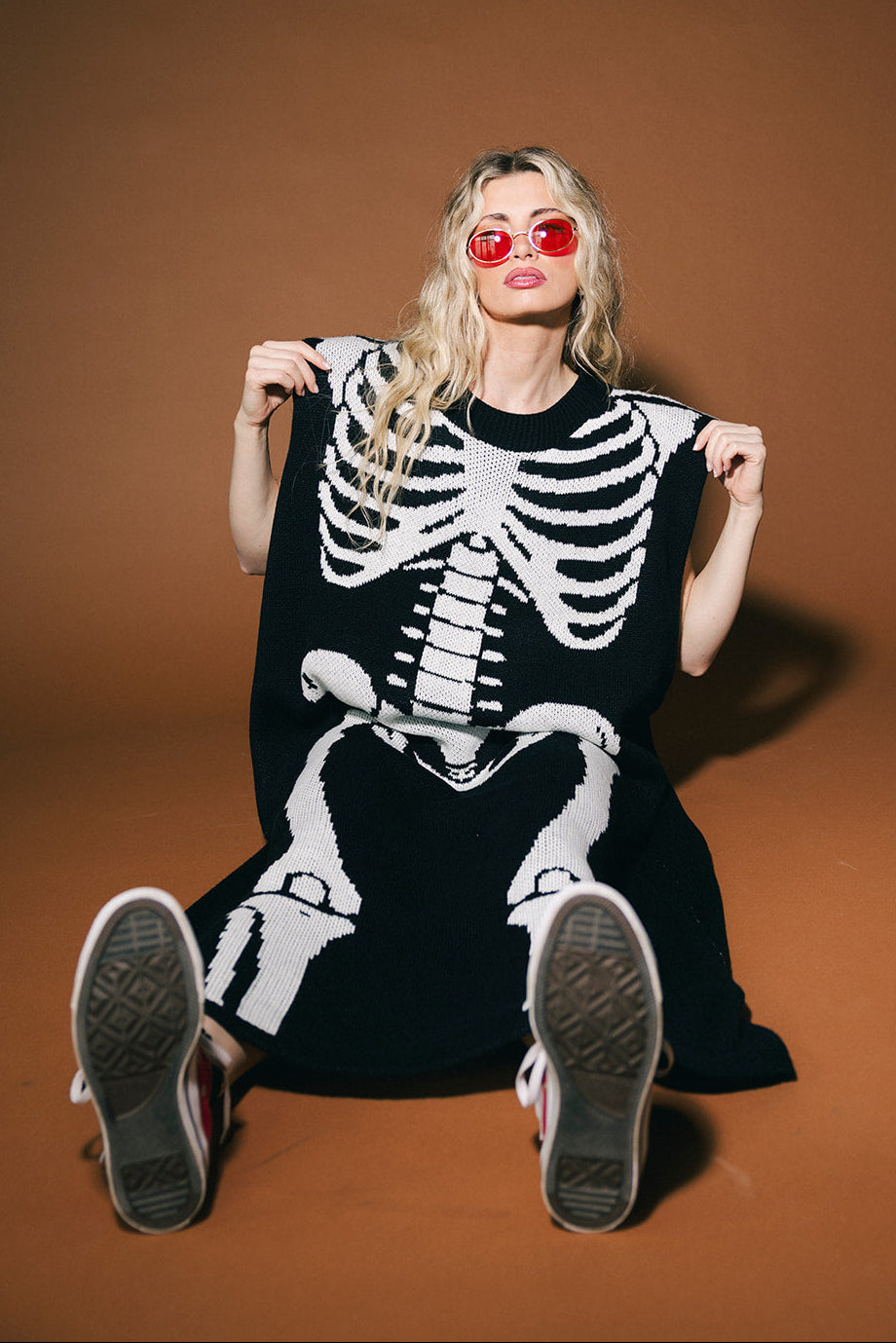 Person wearing a skeleton-themed outfit on a brown background