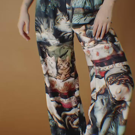 Video of woman wearing trousers with design of cats eating at the Last Supper.