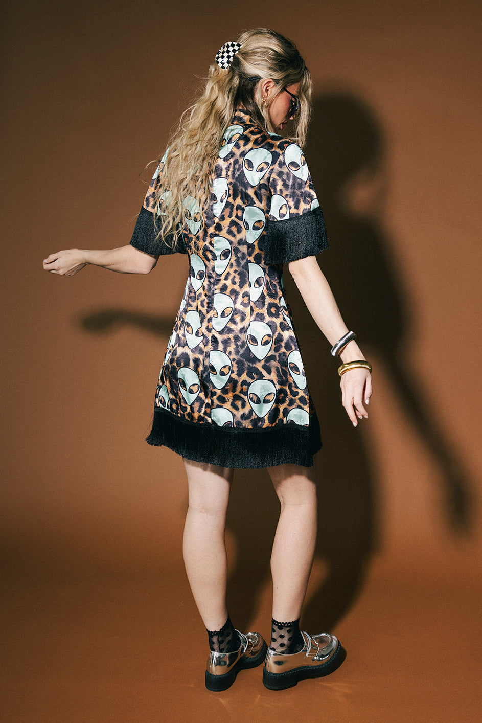 Woman wearing a patterned dress with a brown background